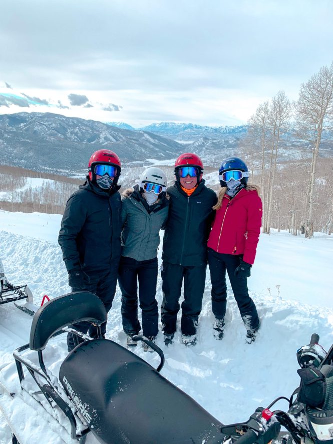 friends in ski gear in the snow with beautiful utah mountains in the background